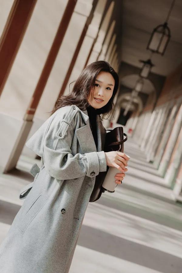 Portrait with a coffee cup in the side light of the Hofgarten arcades.